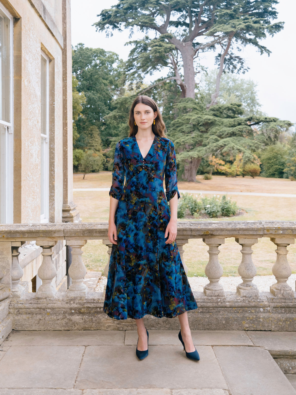 A navy floral printed silk dress with a V neck and three quarter sleeves