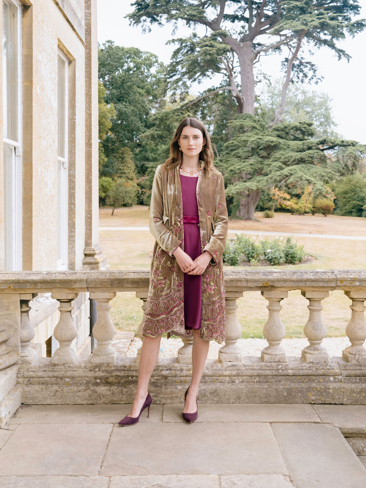 An olive embroidered velvet coat worn over a burgundy silk dress, for the mother of the bride or groom