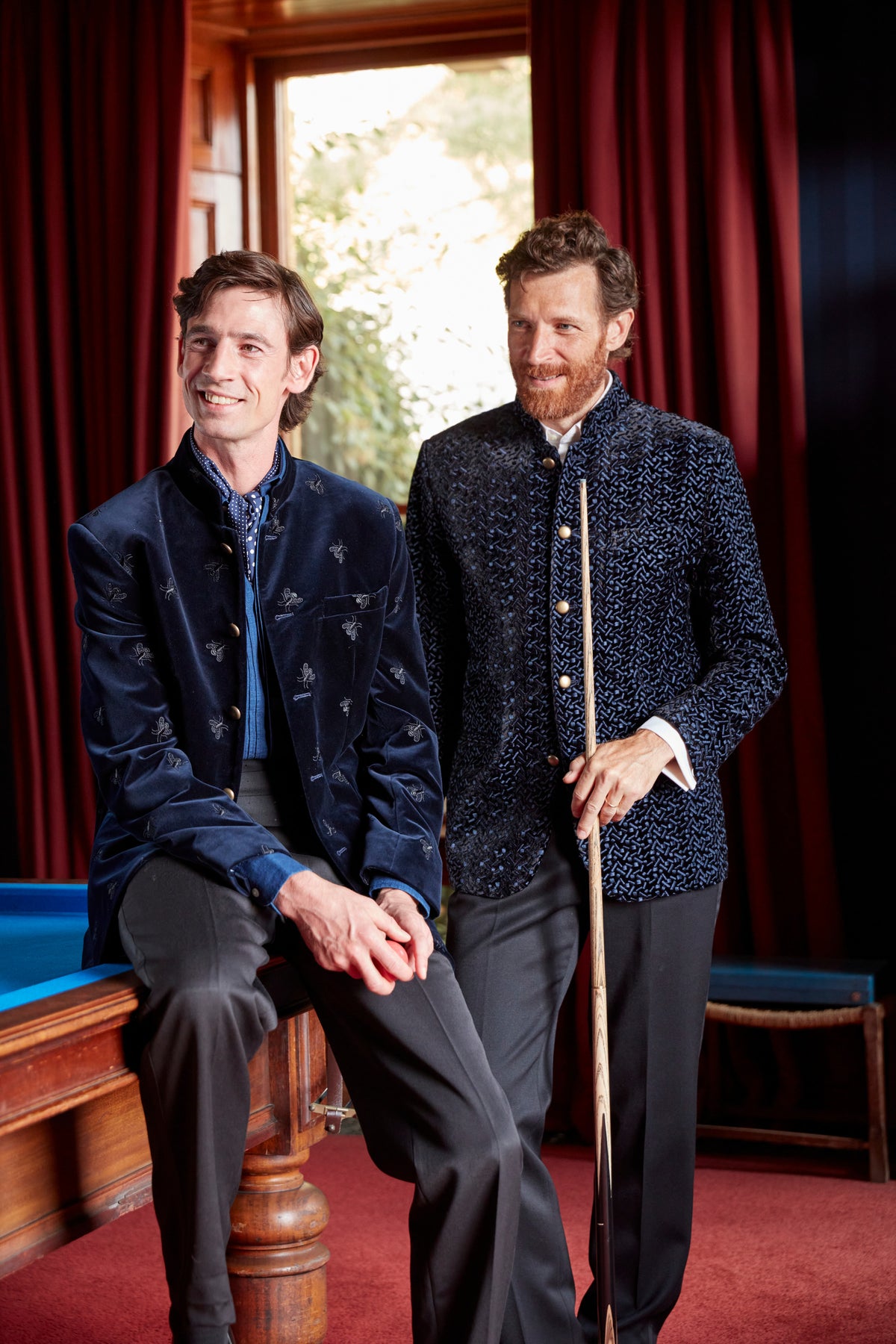 Two models in embroidered navy velvet Nehru jackets in the billiard room at Neston Park