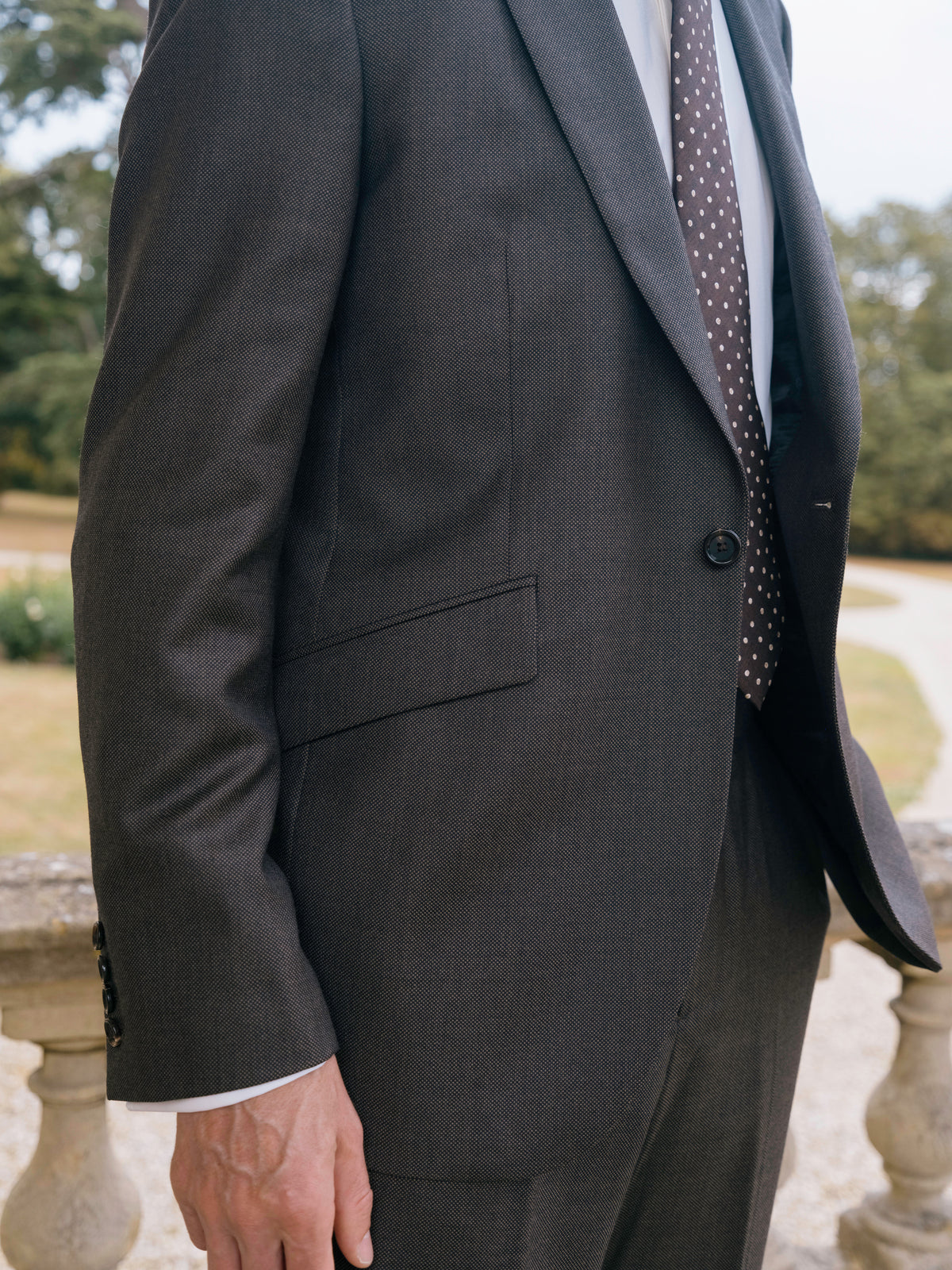 Close detail of grey flannel suiting, showing the cloth, the cuff and a spotted tie