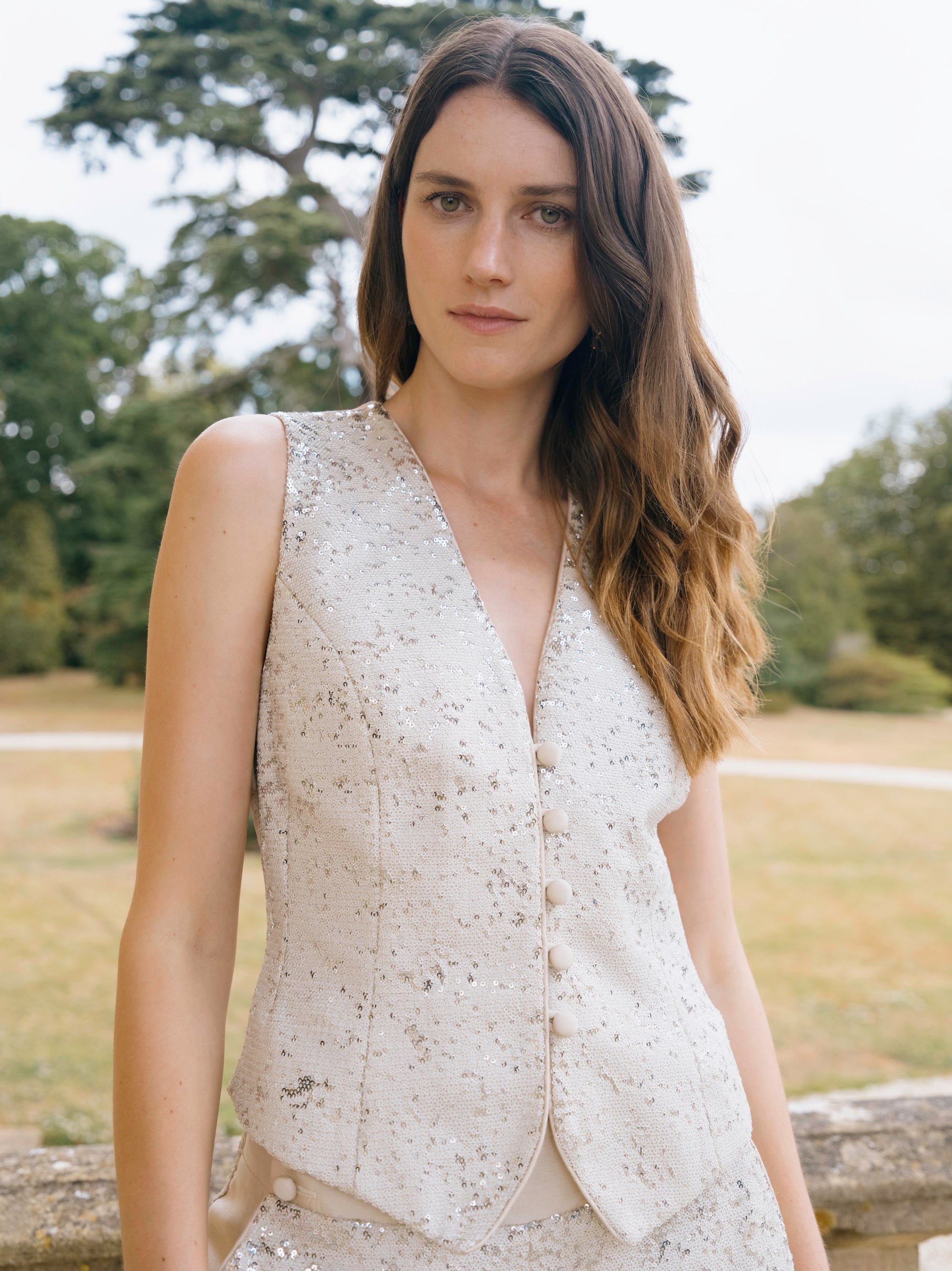 An ivory sequinned waistcoat worn with ivory trousers